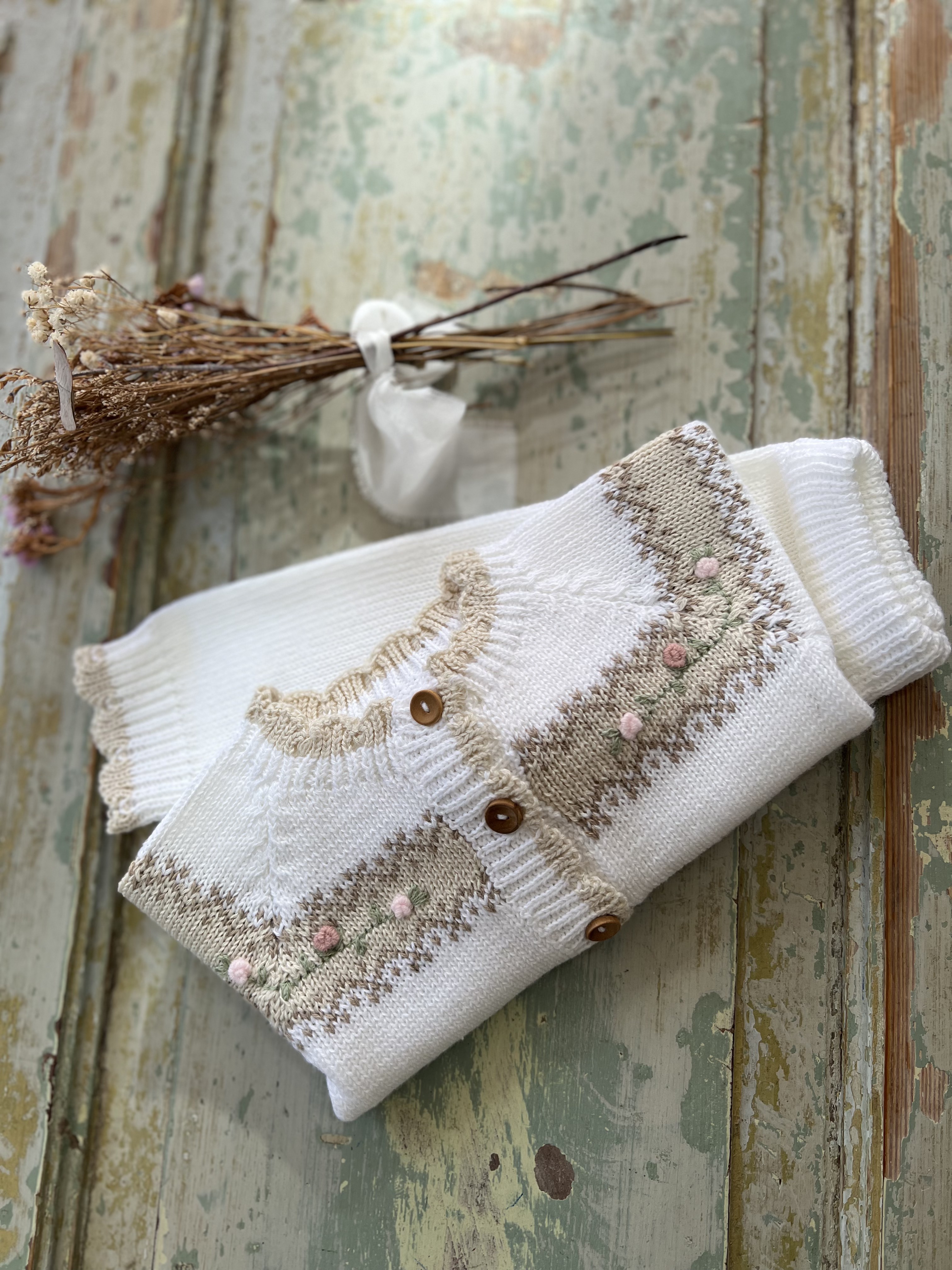 Detalle del cardigan tejido Ginebra con flores y detalles tostados