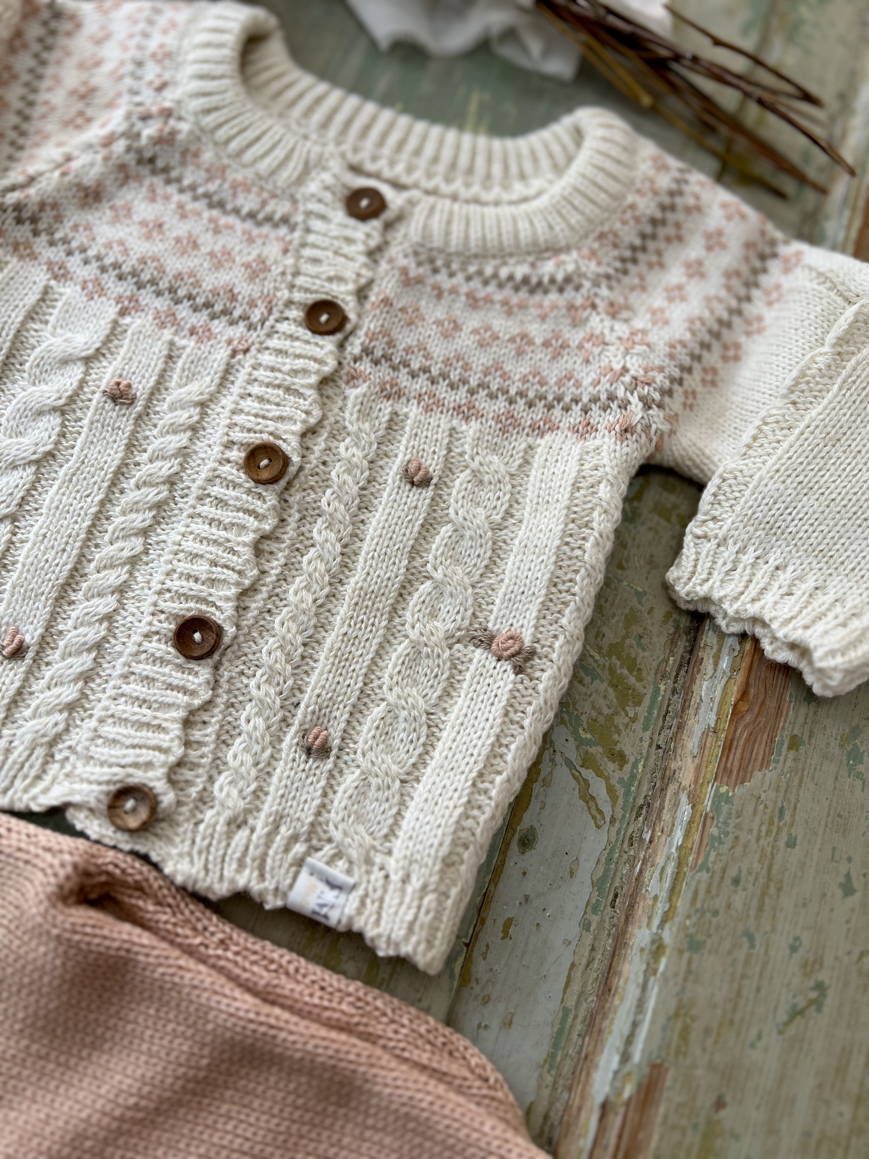 Detalle del cardigan tejido Venecia con motivos florales y trenzas