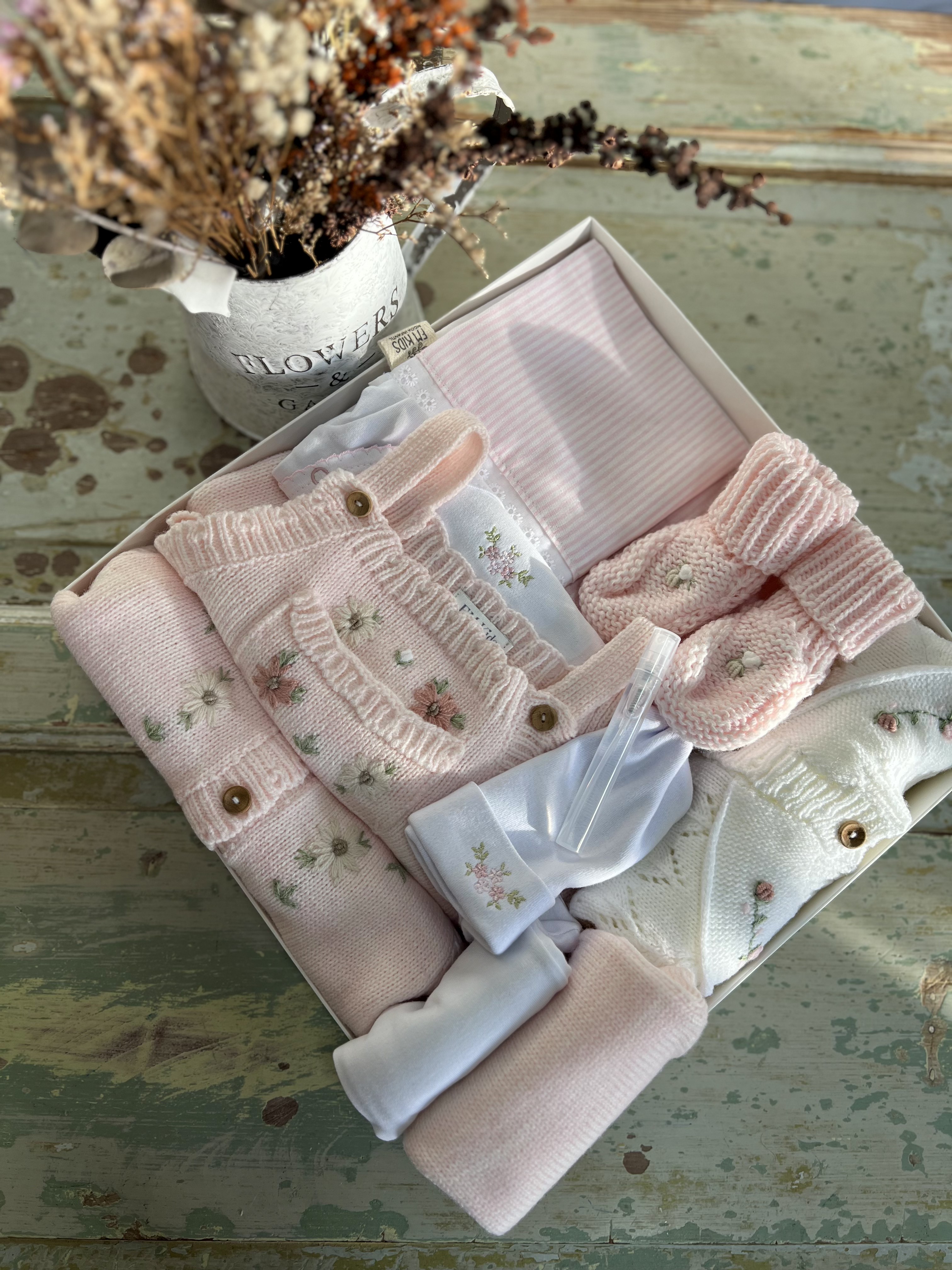 Baby Box rosada con prendas tejidas y accesorios delicados